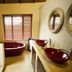 Pilanesberg Private Lodge bathroom with twin red vessel sinks, bathtub and window blinds in Pilanesberg