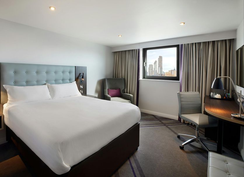 Premier Inn Birmingham City - Waterloo St guest room with king bed, desk, chair and city skyline view