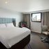 Premier Inn Birmingham City - Waterloo St guest room with king bed, desk, chair and city skyline view