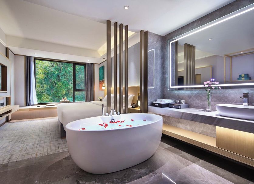 Guilin Yangshuo Shixi Landscape Hotel in Guilin bathroom with freestanding tub, large window and stone vanity