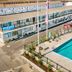 Surf House in Hampton with outdoor pool, sun loungers and courtyard seating beside the motel