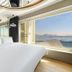 Jk Hotel Busan room with king bed and large window overlooking the sea and distant mountains