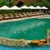 Ho Tram Beach Boutique Resort & Spa in Ba Ria features a curving outdoor pool beside lounge chairs and beach umbrellas.