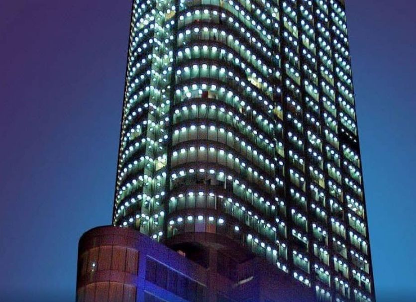 Shangmao International Hotel in Nanjing, illuminated high-rise tower against the evening sky
