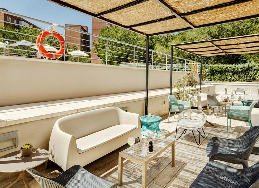 Sercotel Madrid Aeropuerto in Madrid: outdoor terrace with pergolas, seating, and lounge chairs