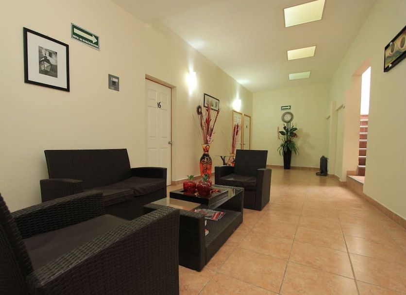 Hotel Santa Rita Guanajuato lobby seating area with wicker chairs, sofa, coffee table, and hallway