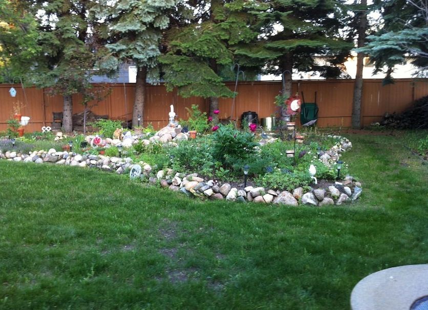 College Park Bed & Breakfast in Saskatoon garden with lawn, flower beds, and trees