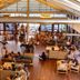 Heron Island Resort lobby lounge on Heron Island with guests seated in a spacious glass-walled atrium