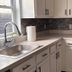 Nwk 457 Room 111-A in Newark kitchen with sink, stove, beige cabinets, and stone tile backsplash