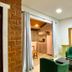 Hospedagem Central in Tiradentes guest room with green chair, mirror, and open doorway to kitchenette