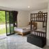 Phangan Great Bay Resort in Ko Pha Ngan room with two beds, sofa, and sliding glass door to greenery