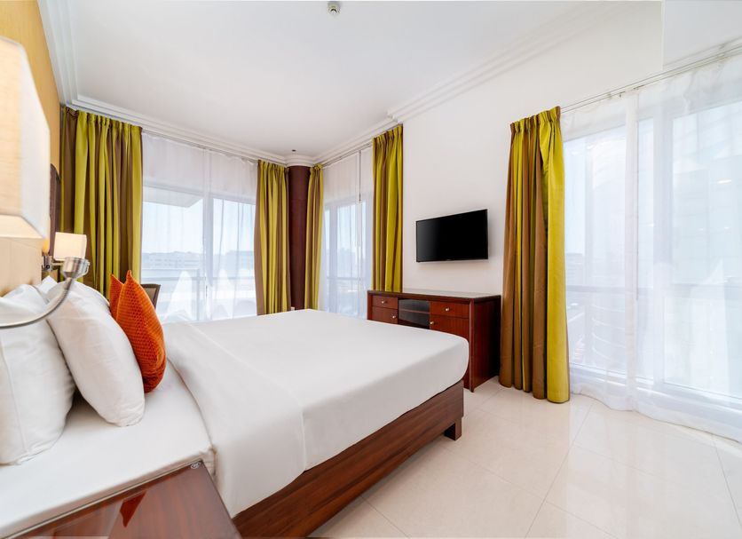 Star Metro Deira Hotel Apartments Dubai guest room with king bed, TV, and large windows