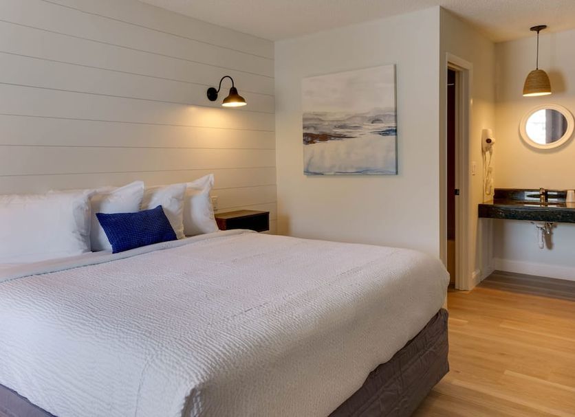 The Shore House in Ocean City guest room with king bed, wall sconces and a vanity area