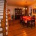 Gîte Au Coin De La Berge in Perce dining room with wooden floors and table set under warm lighting