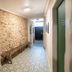 Les Suites de Bellac hallway in Bellac with stone wall, bench and patterned tile floor