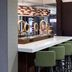 Courtyard by Marriott Tuscaloosa lobby bar with green stools, ring lights and a marble counter