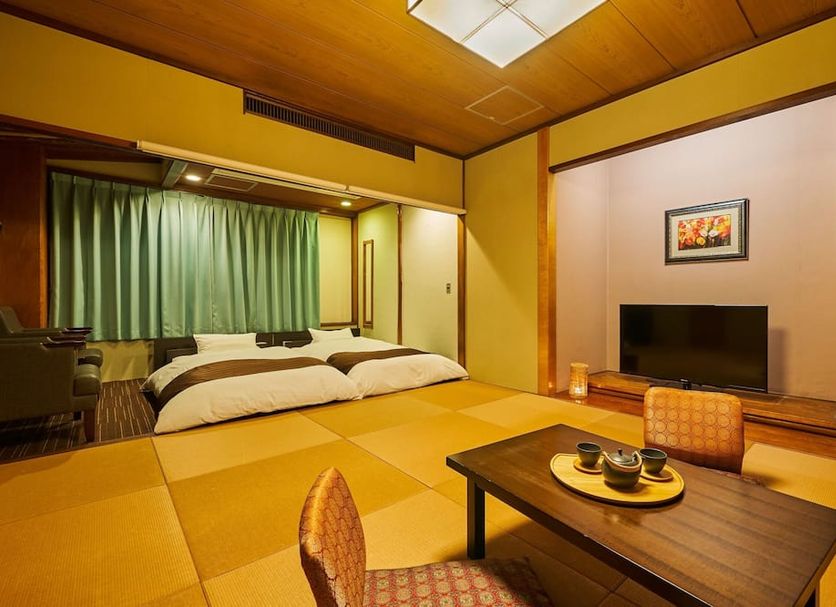 Ooedo Onsen Monogatari Kaike in Yonago: tatami room with futons, low table, and TV
