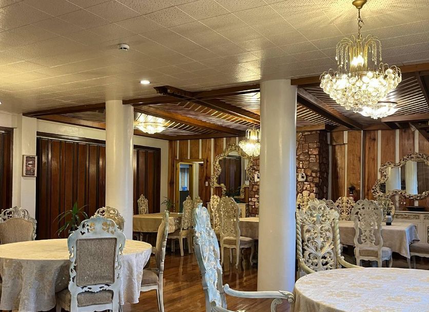 Villa Silvina Hotel And Restaurant in Baguio dining room with chandeliers and round tables
