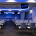 A Point Porto Ercole Resort & Spa conference room with rows of white chairs and blue ceiling lighting