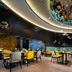 Hampton By Hilton Beijing Wangjing dining area with yellow chairs, blue booths and mirrored ceiling