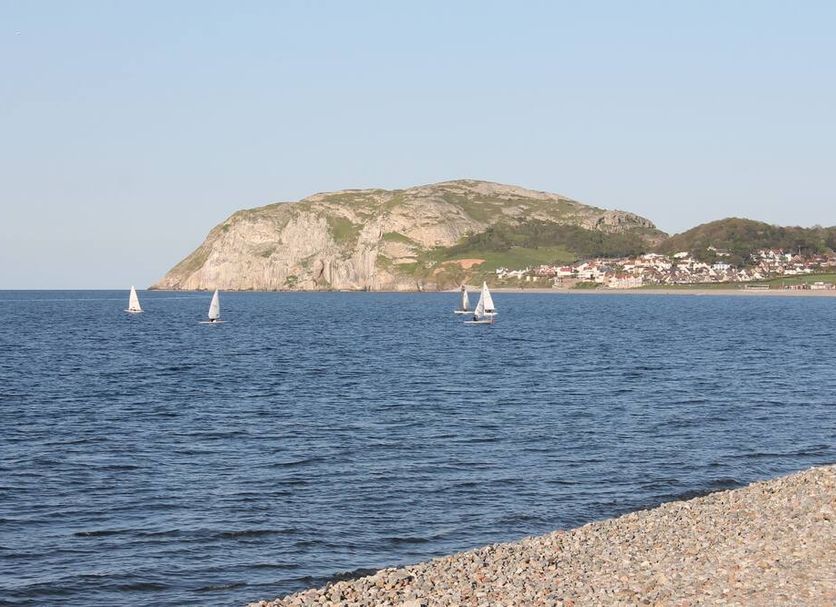 Chatsworth House Hotel in Llandudno with sea view, sailboats, and rocky coastline
