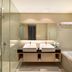 Swiss-Belhotel Mangga Besar Jakarta bathroom with double sinks, glass shower, and bathtub