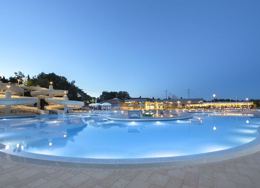 Maistra Select Villas Rubin Resort in Rovinj with a large illuminated outdoor pool at dusk