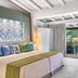 Forte Village Resort - Pineta in Pula bedroom with sliding doors to a balcony and tropical garden view