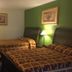 Budget Inn and Suites El Centro guest room with two beds, bedside lamp, and framed wall art