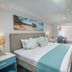 Blue Haven Holiday Apartments in Christchurch bedroom with king bed and tropical wall art