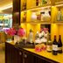 Hôtel Baume in Paris lounge with yellow seating, bar shelves, and a dining area by the garden