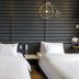 Jk Hotel Busan room with two beds, black slatted wall, and bicycle wall decor