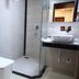 Hotel Tridev Varanasi bathroom with toilet, glass shower stall, and vessel sink