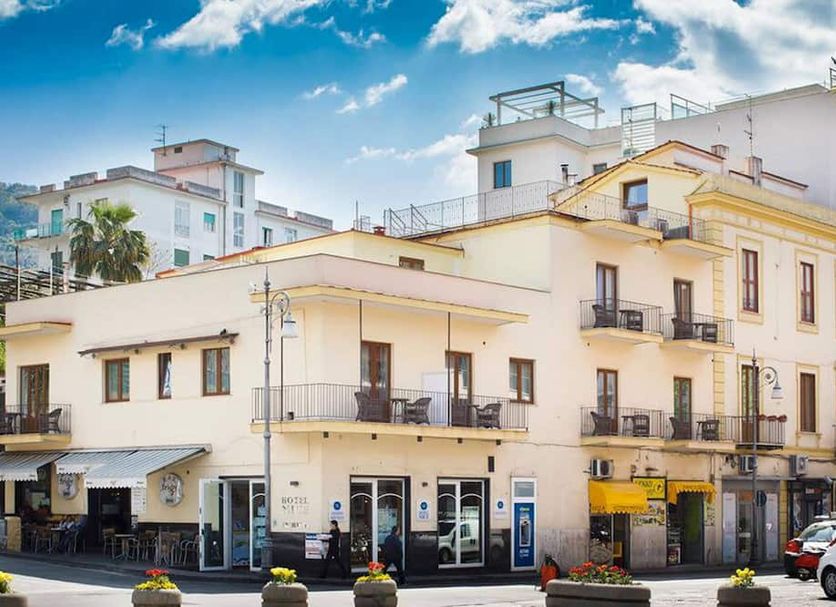 Hotel Nice in Sorrento, street-view of a cream-colored hotel with balconies and rooftop terrace
