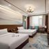 Liuhu Hotel (Hot Spring Garden Hotel) in Dezhou guest room with twin beds, sofa and wall-mounted TV