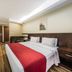 Plaza Bittar Hotel in Brasilia guest room with a double bed, red runner, wood flooring and desk