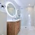 Logis Hotel Bergeret Sport bathroom in Hendaye with walk-in shower, vanity and illuminated round mirror