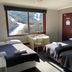 Winterhaus Lodge, Thredbo room with three beds and a mountain view through the window