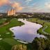 The Ritz-Carlton Orlando Grande Lakes overlooking a golf course and lake at sunset in Orlando