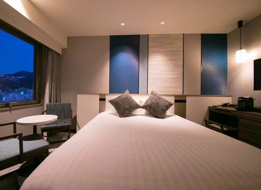 Hotel Jal City Nagasaki room with twin bed, window view, and seating area in Nagasaki