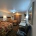 Deluxe Inn Capital O Nebraska City I 29 room with two beds, desk chair, and curtains in Nebraska City