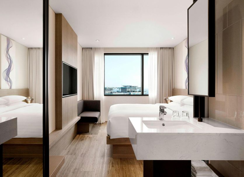 Fairfield by Marriott Busan guest room with twin beds, vanity, TV and city view in Busan
