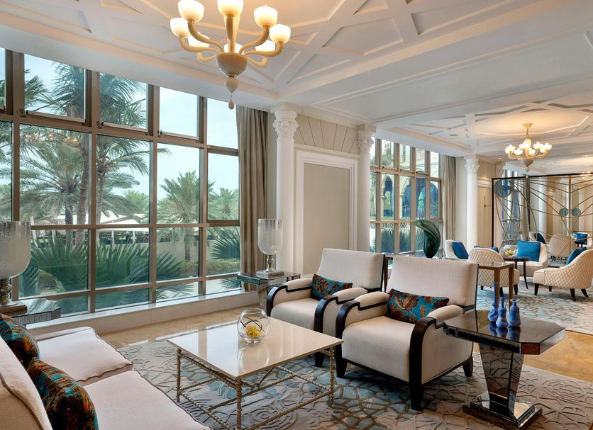 Waldorf Astoria Ras Al Khaimah lounge with palm views through large windows and chandeliers