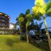 Sinclairs Bayview in Port Blair with a lit multi-story building, palm trees, and landscaped lawn at dusk