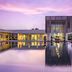 Al Zorah Beach Resort in Ajman with a modern waterfront building reflecting in a calm pool at sunset