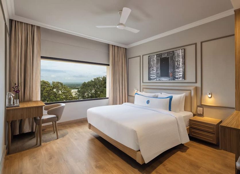 Fortune Valley View, Manipala guest room with king bed and large window overlooking greenery