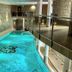 Indoor pool at Hotel & Spa Wasserschloss Westerburg in Huy with stone walls and glass railing