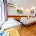 Home Hotel Hanoi guest room with two beds, wood floors, air conditioning and wall art
