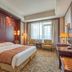 Li An Hotel Hohhot guest room with double bed, armchairs, desk and large window