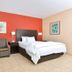 La Bonita Inn & Suites - Mccamey guest room with bed, sofa, and colorful accent walls in McCamey